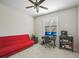 Bedroom with a red futon, ceiling fan and workstation at 1655 Pinyon Pine Dr, Sarasota, FL 34240