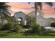 Stunning home exterior with a well-manicured lawn and lush tropical landscaping in a quiet neighborhood at 1655 Pinyon Pine Dr, Sarasota, FL 34240