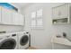 Functional laundry room features a washer and dryer, plus convenient storage cabinets at 1655 Pinyon Pine Dr, Sarasota, FL 34240