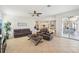 Comfortable living room featuring leather seating, ceiling fan, and access to outdoor living area at 1655 Pinyon Pine Dr, Sarasota, FL 34240