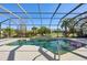 Screened-in pool surrounded by lush landscaping and an expansive patio area with clear blue skies above at 1655 Pinyon Pine Dr, Sarasota, FL 34240