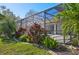 Landscaped backyard with a screened-in patio perfect for outdoor entertaining and relaxation at 1655 Pinyon Pine Dr, Sarasota, FL 34240