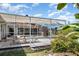 Inviting backyard with enclosed pool, hot tub, picnic table, and lush tropical landscaping at 1730 Hudson St, Englewood, FL 34223