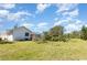 Large grassy backyard with lush tropical landscaping and a view of the home's exterior at 1730 Hudson St, Englewood, FL 34223
