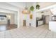 Open kitchen with white cabinets, tile floors, modern appliances and a view of the living area at 1730 Hudson St, Englewood, FL 34223