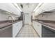 Galley kitchen with white cabinetry, stainless steel appliances, and tile flooring at 1730 Hudson St, Englewood, FL 34223