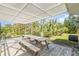 Open-air patio area with a wooden picnic table and a shaded overhead trellis at 1730 Hudson St, Englewood, FL 34223