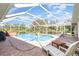 Relaxing screened-in pool area with comfortable lounge chairs, hot tub, and clear blue water at 1730 Hudson St, Englewood, FL 34223