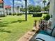 A serene outdoor space featuring a grassy lawn, palm trees, and a glimpse of the ocean at 1801 Gulf N Dr # 184, Bradenton Beach, FL 34217