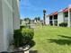 Exterior view of community buildings with pond, lush grass, and mature palm trees at 1801 Gulf N Dr # 184, Bradenton Beach, FL 34217