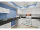 Well-lit kitchen featuring white cabinets, granite counters, and a stylish backsplash at 1832 University Pl # 23, Sarasota, FL 34235