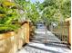 Private gated entrance with decorative metalwork and lush tropical foliage at 2212 6Th W St, Palmetto, FL 34221