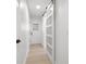Hallway with modern white paneled glass sliding door and white door with black hardware at 2846 Pheasant Run, Clearwater, FL 33759