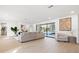 Bright living room with modern decor, sliding glass doors to the pool, and comfortable seating at 2846 Pheasant Run, Clearwater, FL 33759