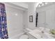 All-white bathroom with tub/shower combo, framed mirror, and nautical themed shower curtain at 285 Madeira Cir, Tierra Verde, FL 33715
