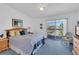 Spacious bedroom features serene blue carpet, queen bed, wood furniture, and balcony access at 285 Madeira Cir, Tierra Verde, FL 33715