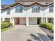 The townhome showcases a neat exterior with a two-car garage and landscaped grounds at 285 Madeira Cir, Tierra Verde, FL 33715
