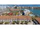 Aerial view of waterfront townhomes featuring lush landscaping, carports, and community tennis courts at 285 Madeira Cir, Tierra Verde, FL 33715