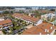 Aerial view of waterfront townhomes with lush landscaping, carports, and community tennis courts at 285 Madeira Cir, Tierra Verde, FL 33715