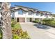Charming townhome features a well-manicured lawn, two-car garage, and distinctive architectural details at 285 Madeira Cir, Tierra Verde, FL 33715