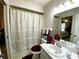 Cozy bathroom showcasing a shower with a decorative curtain, a sink, and patterned wallpaper at 3002 Vivienda Dr # 22, Bradenton, FL 34207