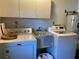 Functional laundry room with a washing machine, dryer, laundry sink, and upper storage cabinets at 3002 Vivienda Dr # 22, Bradenton, FL 34207