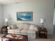 Comfortable living room with a floral sofa, coastal artwork, side tables, and a glass-topped coffee table at 3002 Vivienda Dr # 22, Bradenton, FL 34207