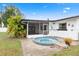 Backyard featuring a screened-in porch, hot tub, well maintained lawn, and white fencing at 3016 Taunton W Dr, Bradenton, FL 34205