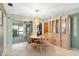 Bright dining area with sliding doors to outdoor screened space, complemented by a decorative chandelier and display cabinet at 3016 Taunton W Dr, Bradenton, FL 34205