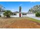 Charming single story home with a well-manicured lawn, beautiful landscaping and a vibrant red front door at 3016 Taunton W Dr, Bradenton, FL 34205