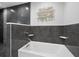 Contemporary bathroom with a soaking tub, gray tile surround, and modern fixtures at 3376 S Seclusion Dr, Sarasota, FL 34239