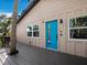 Wood deck featuring a vibrant blue front door, palm trees and multiple windows at 3376 S Seclusion Dr, Sarasota, FL 34239