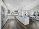 Open-concept kitchen and dining area with island, stainless appliances, and wood-look tile flooring at 3376 S Seclusion Dr, Sarasota, FL 34239