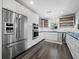 Updated kitchen featuring stainless steel appliances, sleek white cabinetry, and stylish fixtures at 3376 S Seclusion Dr, Sarasota, FL 34239