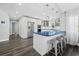Modern kitchen featuring stainless steel appliances, white cabinets, and a blue countertop island with seating at 3376 S Seclusion Dr, Sarasota, FL 34239