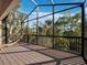 Spacious screened patio with a hammock and beautiful views of the surrounding trees and clear sky at 3376 S Seclusion Dr, Sarasota, FL 34239