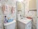 Charming bathroom featuring floral wallpaper, decorative towels, and a vanity with a bright countertop at 3424 Lake Bayshore Dr # 405, Bradenton, FL 34205