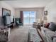 Cozy living room with comfortable seating, carpeted floors, and sliding glass doors that offer a view of the lake at 3424 Lake Bayshore Dr # 405, Bradenton, FL 34205