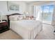 Comfortable main bedroom featuring a cozy bed and sliding glass doors leading to a balcony with a lake view at 3424 Lake Bayshore Dr # 405, Bradenton, FL 34205