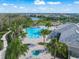 Aerial view of a large community pool, hot tub, playground, and nearby clubhouse at 3442 Chestertown Loop, Bradenton, FL 34211