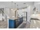Modern kitchen featuring white cabinets, stainless steel appliances, and a stylish blue kitchen island at 3442 Chestertown Loop, Bradenton, FL 34211