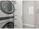 Modern laundry room featuring stacked washer and dryer, and matching custom cabinets at 3442 Chestertown Loop, Bradenton, FL 34211