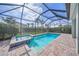 Relaxing screened-in pool area with spa, beautiful blue water and brick pavers at 3442 Chestertown Loop, Bradenton, FL 34211