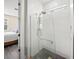 Bright, glass-enclosed shower with gray tile floor and a view to the bedroom at 3442 Chestertown Loop, Bradenton, FL 34211