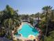 Aerial view of the community pool area featuring lush landscaping, a spa, and comfortable lounging at 3701 54Th W Dr # 103, Bradenton, FL 34210
