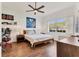 Cozy bedroom with a ceiling fan, wood floors, and a large window for natural light at 3701 54Th W Dr # 103, Bradenton, FL 34210