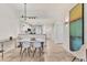 Open concept dining area with a white dining table, modern lighting, and tile flooring at 3701 54Th W Dr # 103, Bradenton, FL 34210