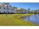 Beautiful view of grassy lawn with a water view of pond and building in the background at 3701 54Th W Dr # 103, Bradenton, FL 34210