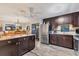 Open kitchen with stainless steel appliances and dark wood cabinetry, island, and open to dining area at 3912 14Th E St, Ellenton, FL 34222