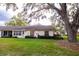 Exterior view of the home with lawn, mature trees, and screened porch at 4018 Oakhurst Dr # 3181, Sarasota, FL 34233